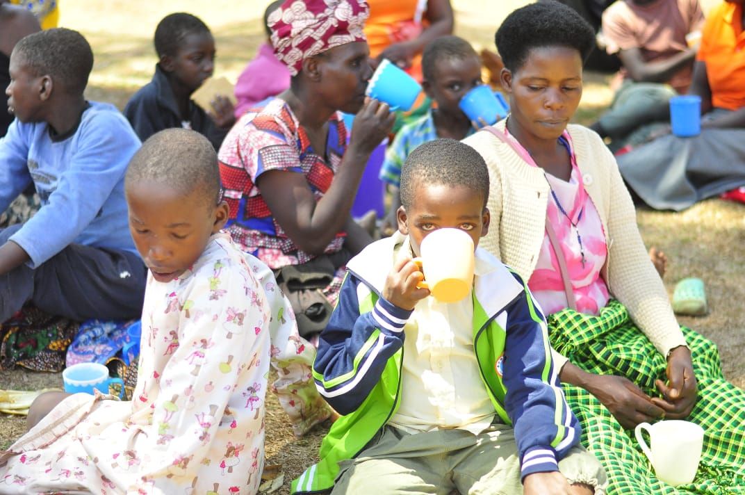 Children and mothers sharing refreshments at the solar distribution
