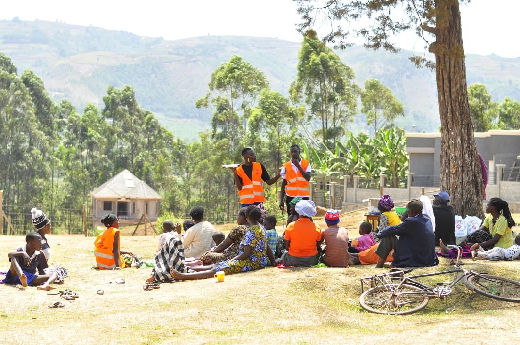 Community members seated under trees during a solar orientation session